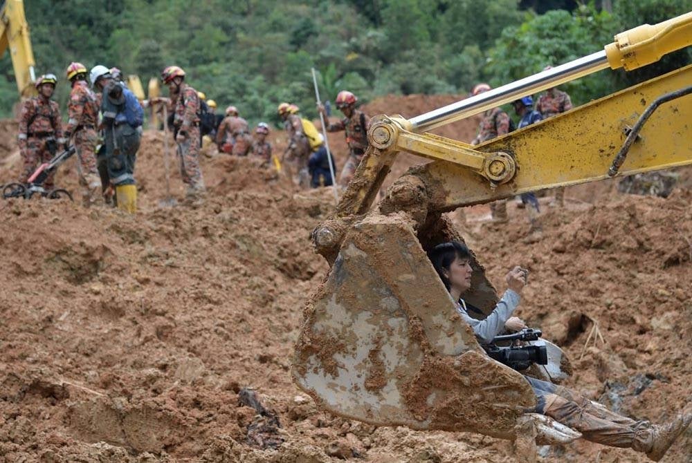 Christine ketika merakam video di lokasi tragedi tanah runtuh di tapak perkhemahan Hilltop di Father's Organic Farm, Jalan Genting, Batang Kali di sini. Foto: The Malaysian Insight