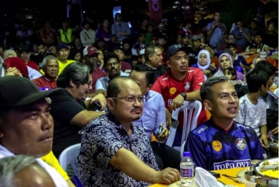 Fahmi (kanan) bersama orang ramai yang hadir menyaksikan perlawanan akhir Piala Dunia Qatar antara pasukan Perancis dan Argentina pada Program Jom Tonton Perlawanan Akhir Piala Dunia Qatar 2022 di Kompleks Sukan Ecopark, Pantai Dalam malam tadi. - Foto Bernama