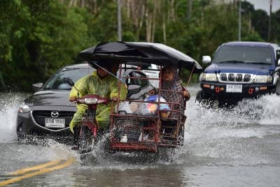 Pengguna kenderaan melalui jalan dilimpahi air banjir berikutan hujan lebat di Kampung Lampu di wilayah Narathiwat di selatan Thailand pada Isnin. - Foto AFP
