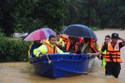 Anggota pasukan penyelamat membantu memindahkan mangsa banjir di Kampung Baroh Masin, Pasir Akar, Hulu Besit dengan menggunakan bot pada Ahad. - Foto Bernama