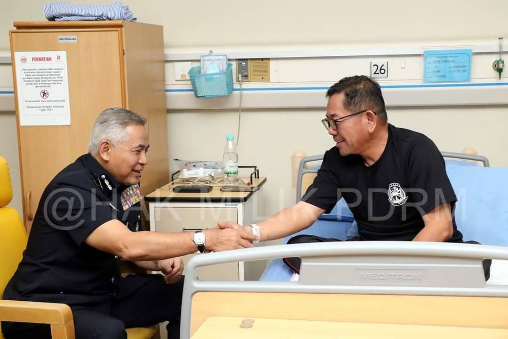 Acryl Sani (kiri) meluangkan masa melawat Norazam (kanan) yang diserang strok ringan di Hospital Selayang pada Isnin. Foto PDRM