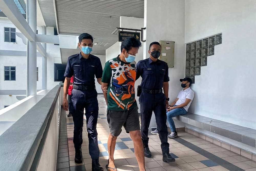 Tertuduh (dua dari kiri) ketika keluar dari Mahkamah Majistret Melaka pada Selasa.