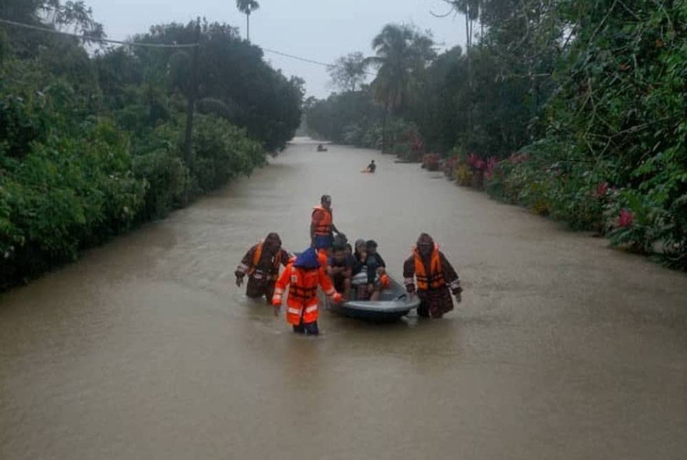 Pasukan keselamatan membantu memindahkan mangsa yang terjejas banjir di Terengganu. - Foto APM