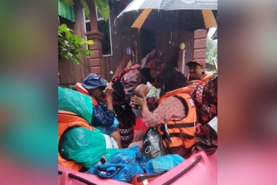 Anggota bomba memindahkan lapan sekeluarga termasuk bayi berusia 40 hari di Kampung Pulau Rusa Hilir di Kuala Terengganu ke PPS di SK Paloh. - Foto ihsan JBPM Terengganu