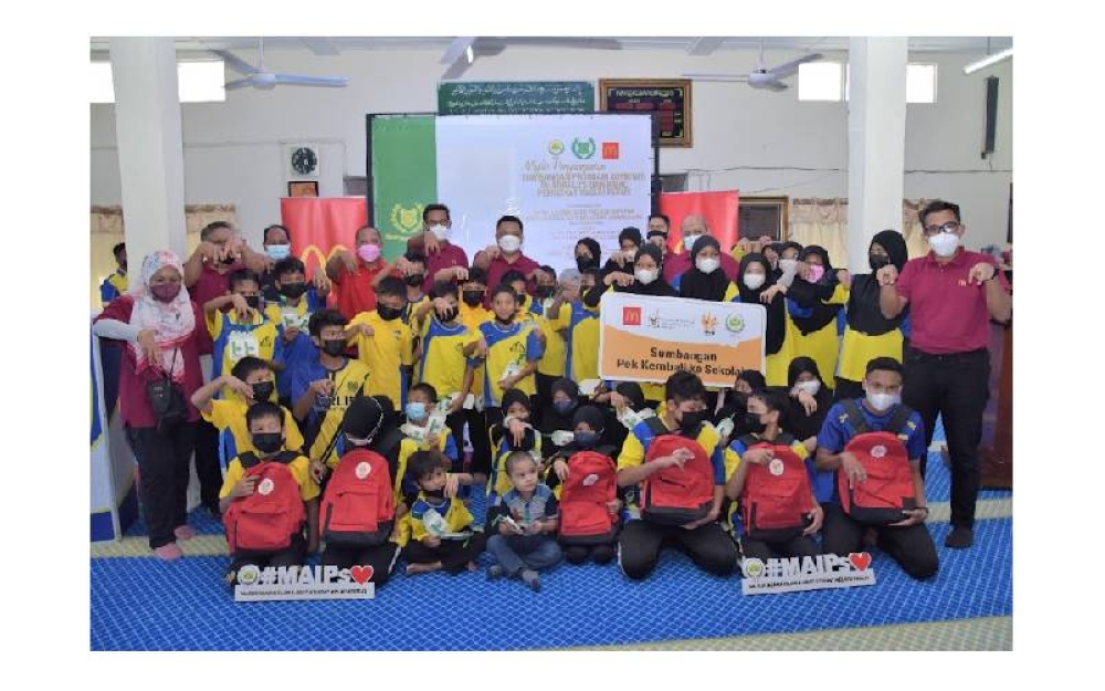 Tuanku Syed Faizuddin Putra bergambar bersama pelajar sekolah rendah dari Perlis yang menerima sumbangan berkenaan.