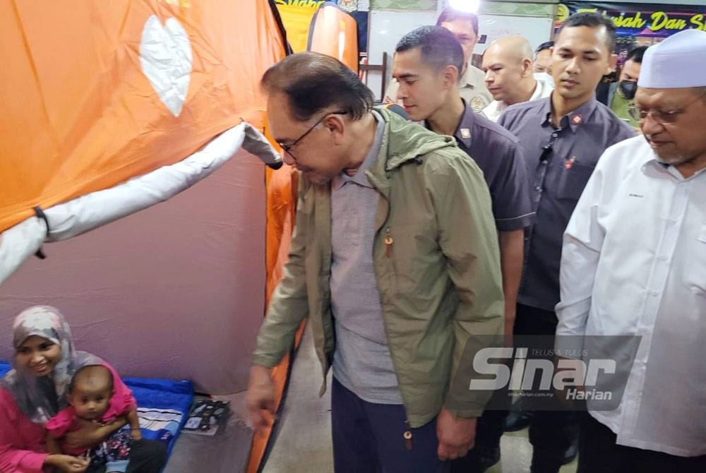 Anwar bersama Ahmad (kanan) mengadakan lawatan di PPS Sekolah Menengah Kebangsaan (SMK) Tengku Panglima Raja, Pasir Mas pada Rabu
