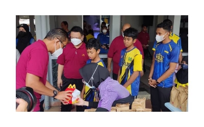 Raja Muda Perlis, Tuanku Syed Faizuddin Putra Tuanku Syed Sirajuddin Jamalullail bersama Pengarah Urusan dan Rakan Operasi Tempatan McDonald’s Malaysia, Datuk Azmir Jaafar (kiri) menyerahkan sumbangan makanan kepada pelajar sekolah rendah dari Perlis yang menerima Pek Kembali ke Sekolah.