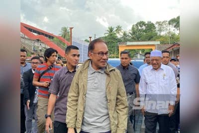 Anwar (hadapan) bersama Menteri Besar Kelantan, Datuk Ahmad Yakob (kanan) semasa hadir di PPS SMK Tengku Panglima Raja, Pasir Mas pada Rabu.