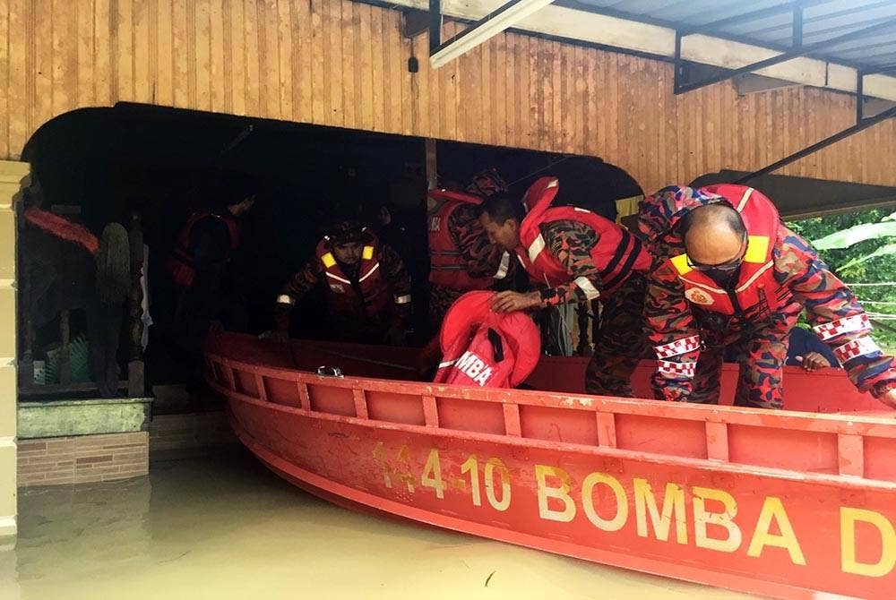Anggota bomba menyelamatkan mangsa banjir di Kampung Jeram, di Kuala Terengganu. - Foto ihsan JBPM Terengganu