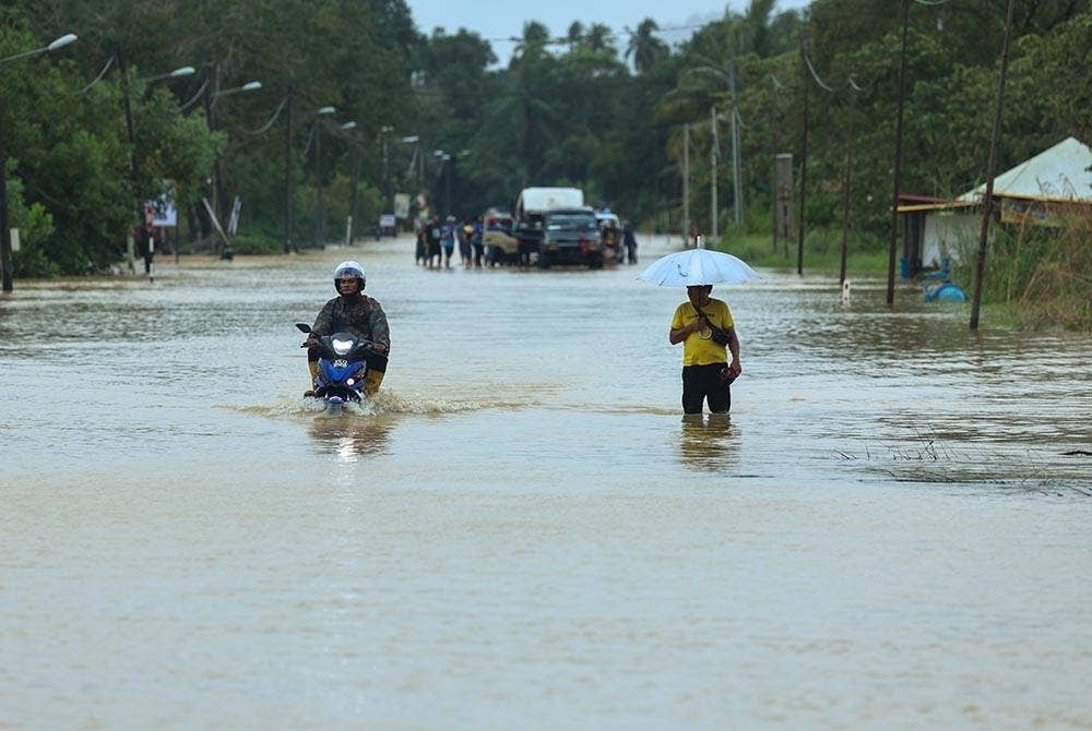 Jalan utama Dungun-Kuala Terengganu ditenggelami air di sekitar kawasan Sungai Nyior Paka pada Rabu. - Foto Bernama