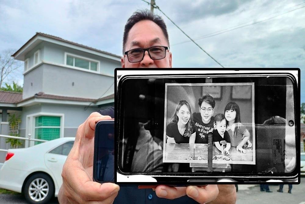 Michael Tai menunjukkan gambar empat beranak mangsa tanah runtuh di Batang Kali.