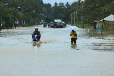 Jalan utama Dungun-Kuala Terengganu ditenggelami air di sekitar kawasan Sungai Nyior Paka pada Rabu. - Foto Bernama