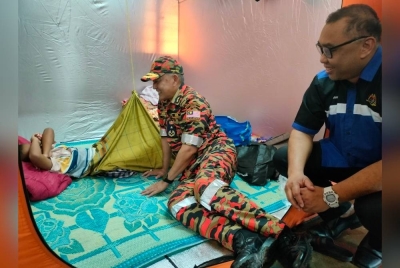 Pengarah Jabatan Bomba dan Penyelamat Malaysia Pahang, Datuk Ir Dr Wan Mohammad Zaidi Wan Isa dan Pengarah JKM Pahang, Datuk Zulkhairi Zainol Abidin menemui Mohd Asyraaf Adha yang sedang berehat ketika melawat PPS SK Sungai Ular, Kuantan pada Khamis.