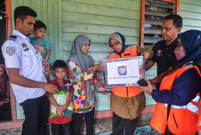 Aiman Athirah (tiga dari kanan) menyampaikan sumbangan kepada ibu mangsa Nurul Ain Bakkeri, 33, (empat dari kiri) dan suaminya, Mohd Sobrey Ramli, 32, (kiri) selepas kejadian anaknya Muhammad Sufi Eijaz ditemui mati lemas di Kampung Telari. - Foto Bernama.