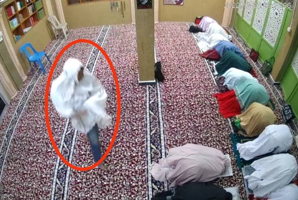 Rakaman CCTV menunjukkan suspek memakai telekung warna putih masuk ke ruangan jemaah wanita untuk mengambil barang berharga.