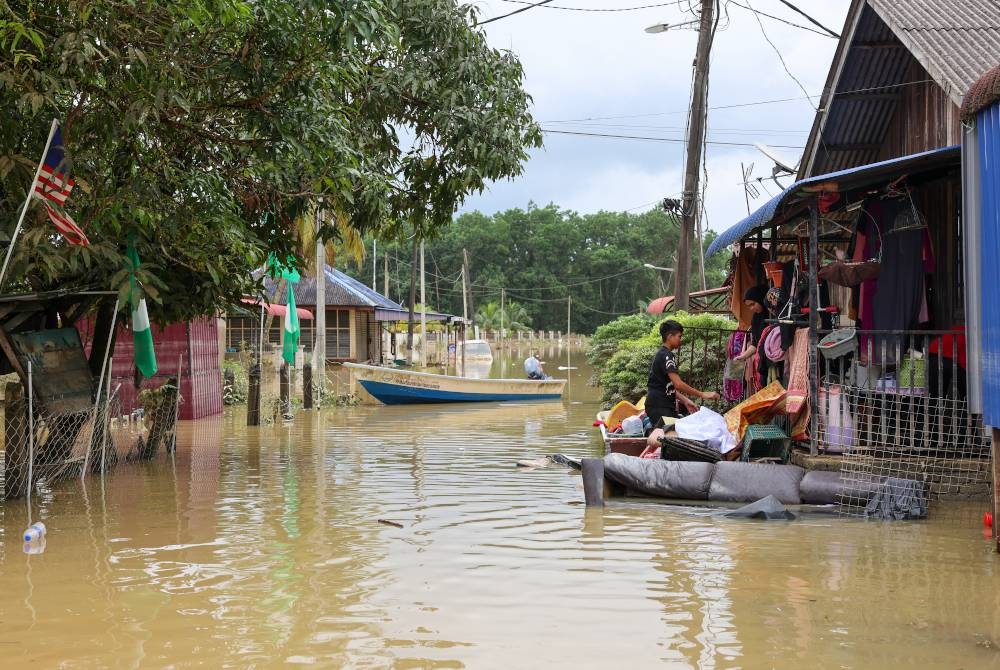 Mangsa banjir mula kembali ke rumah masing-masing untuk membersihkan perabot dan rumah selepas paras air mulai surut di Kampung Durian Mentangau pada Jumaat. - Foto Bernama