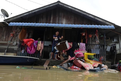 Mangsa banjir mula kembali ke rumah masing-masing untuk membersihkan perabot dan rumah selepas paras air mulai surut di Kampung Durian Mentangau pada Jumaat. - Foto Bernama