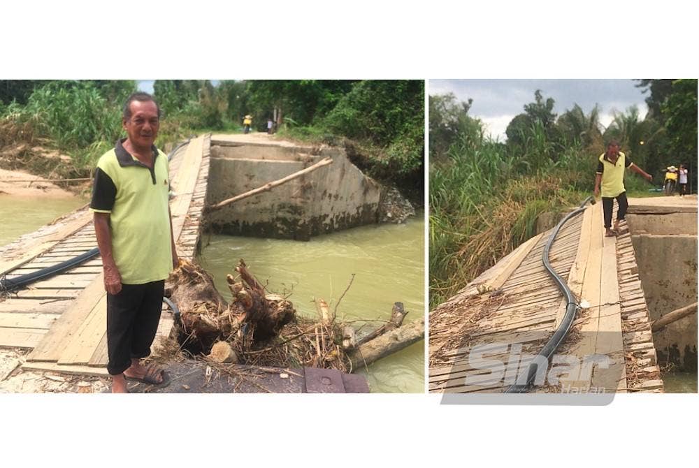 Mansor menunjukkan sisa kayu yang tersangkut pada bahagian jambatan hampir putus. 