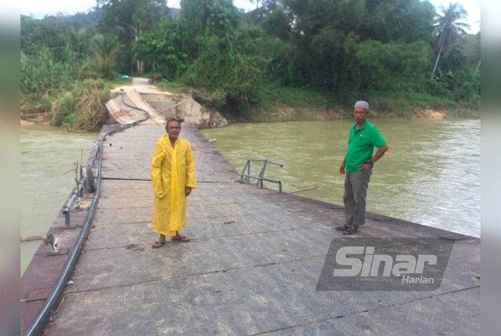 Mohd Roslizi (kanan) dan Jusoh (kiri) berdiri di jambatan di Kampung Temalir, Kuala Krai.