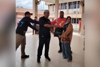 Tuan Kamarul Arief (dua dari kiri) ketika Misi Bantuan Banjir Yadim di Pantai Timur di Sekolah Menengah Kebangsaan Geting pada Jumaat.