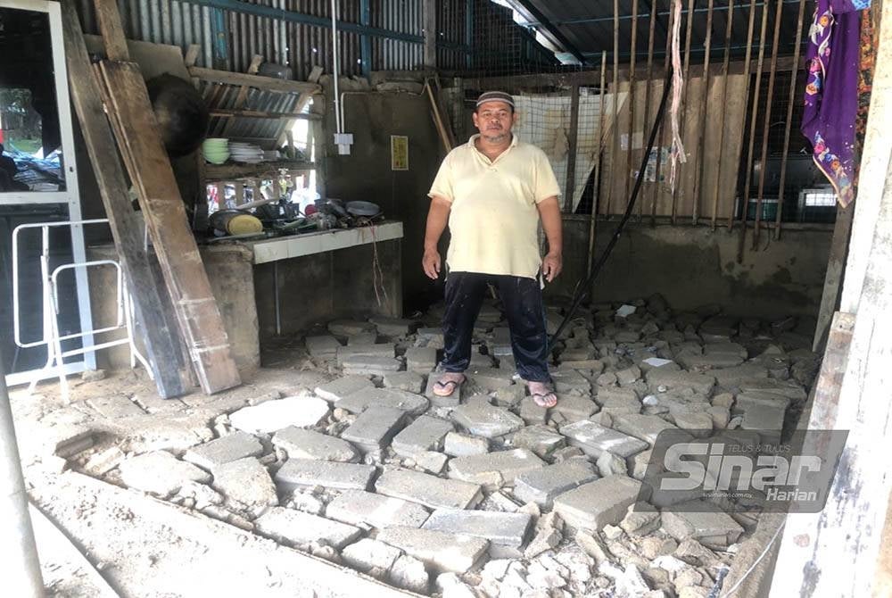 Mohd Asri berdiri di tapak kedai makannya yang hanya tinggal lantai pecah.