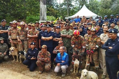Acryl Sani bergambar dengan pasukan operasi SAR tragedi tanah runtuh di tapak perkhemahan Father's Organic Farm, Jalan Genting, Batang Kali, Hulu Selangor pada Ahad