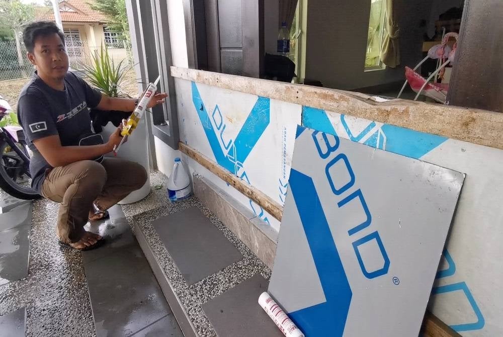Zuhri menunjukkan kaedah pemasangan papan ACP yang dilekatkan menggunakan gam silikon yang berhasil menyelamatkan rumahnya dari dimasuki air ketika banjir melanda kawasan itu pada 20 Disember lalu.