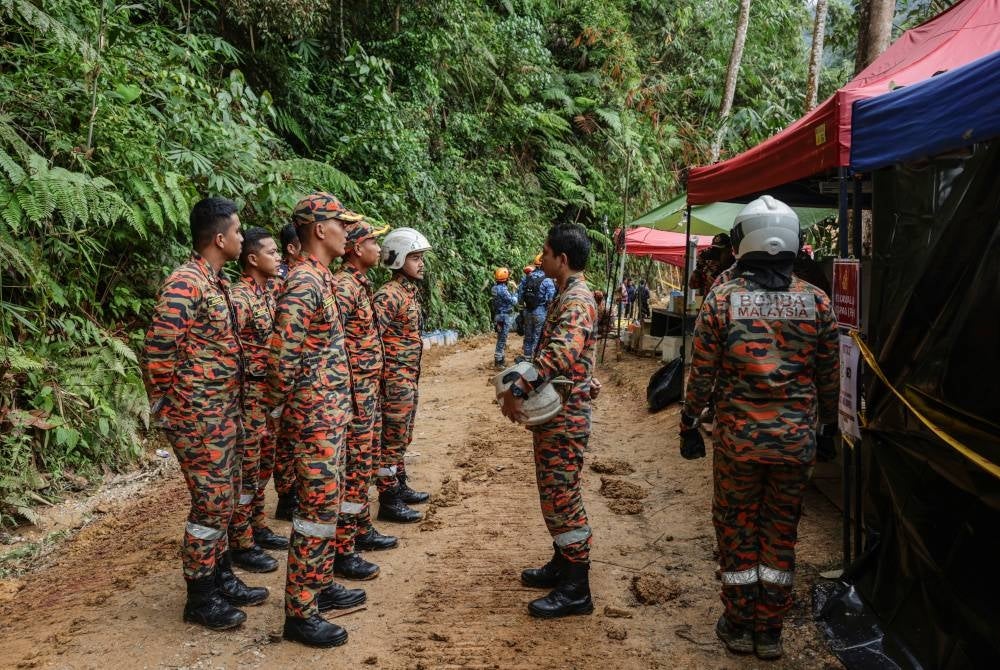 Anggota pasukan Bomba dan Penyelamat Malaysia diberi taklimat sebelum memasuki lokasi tanah runtuh berhampiran tapak perkhemahan di Father's Organic Farm, bagi melakukan kerja-kerja mencari dan menyelamat seorang lagi mangsa yang dipercayai tertimbus akibat tragedi tersebut. - Foto Bernama
