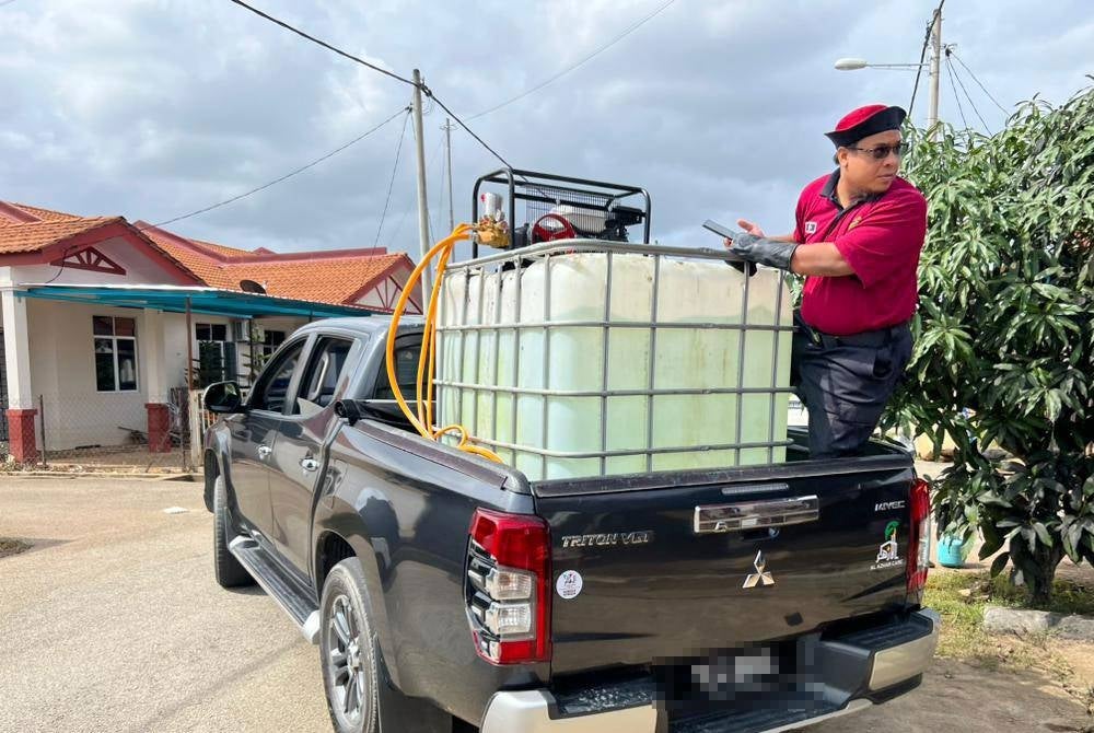 Mohd Hasmizie membantu membawa air untuk membersihkan rumah penduduk terjejas banjir. - Foto Jabatan Amal