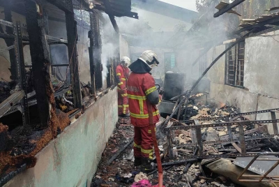 Anggota bomba memadamkan kebakaran di Rumah Persatuan Orang Cacat Johor Bahru di Kampung Ungku Mohsin, Johor Bahru, pada Isnin. - Foto: Bomba