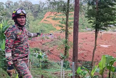 Juyana menunjukkan lokasi mayat kanak-kanak terakhir mangsa tragedi tanah runtuh di tapak perkhemahan di Father's Organic Farm, Jalan Genting- Batang Kali di sini pada Sabtu.
