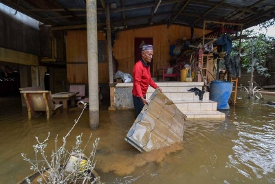 Penduduk Che Ali Che Mud, 60, membersihkan halaman rumah susulan kejadian banjir baru-baru ini selepas air mulai surut ketika tinjauan Kampung Tersang, Rantau Panjang, pada Isnin. - Foto Bernama
