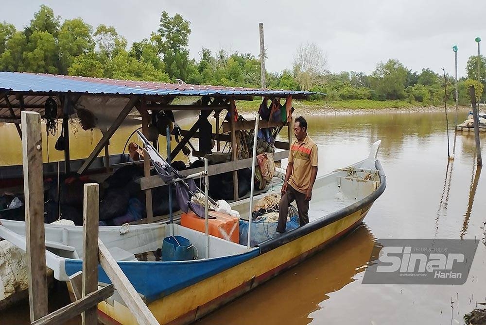 Razali membuat persiapan dengan menyimpan peralatan tangkapan di dalam bot milik di jeti Sungai Miang pada Isnin.
