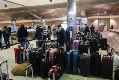 Pengembara memenuhi Lapangan Terbang Metro Detroit Wayne County pada malam Krismas berikutan ribut salji Elliot di Detroit, Michigan pada Sabtu. - Foto AFP