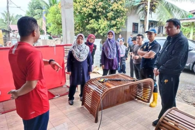 Dr Kasemani (dua dari kiri) bertanya sesuatu ketika mebgunjungi Klinik Desa Kuala Jengai yang turut terjejas banjir.