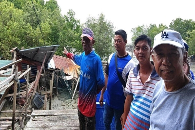 Mohd Asri (kiri) bersama nelayan lain menunjukkan keadaan jeti dan sebuah stor di Jeti Pengkalan Nelayan Sungai Assam Jawa yang runtuh akibat dipukul ribut.