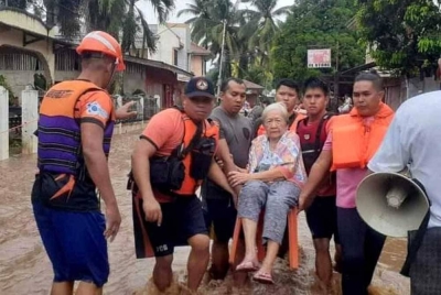 Pekerja penyelamat membantu penduduk yang terjejas akibat banjir, di Plaridel, Wilayah Misamis Occidental, Filipina pada Isnin. - Foto: Reuters