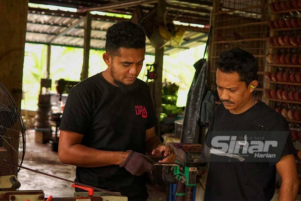 Muhammad Khairi Adham (à gauche) sert des clients qui souhaitent venir de Perlis pour faire produire la machette.