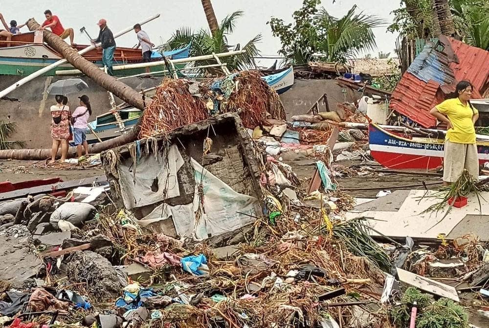 Penduduk meninjau kerosakan akibat hujan lebat dan banjir di Bandar Oroquieta, Misamis Occidental. - Foto AFP/ Ihsan Angelica Villarta