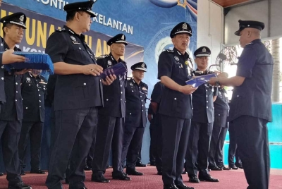 Muhamad Zaki (tengah) menyampaikan sijil penghargaan kepada pegawainya sempena Program Perhimpunan Bulanan Peringkat Ibu Pejabat Polis Kontinjen pada Khamis.