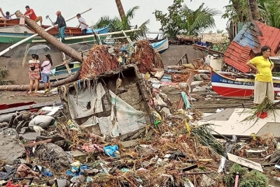 Penduduk meninjau kerosakan akibat hujan lebat dan banjir di Bandar Oroquieta, Misamis Occidental. - Foto AFP/ Ihsan Angelica Villarta