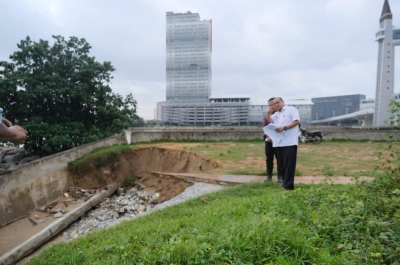 Ahmad Amzad ketika meninjau keadaan hakisan dan runtuhan yang berlaku di laluan pejalan kaki berhampiran jambatan angkat di sini. Foto: Facebook Ahmad Amzad