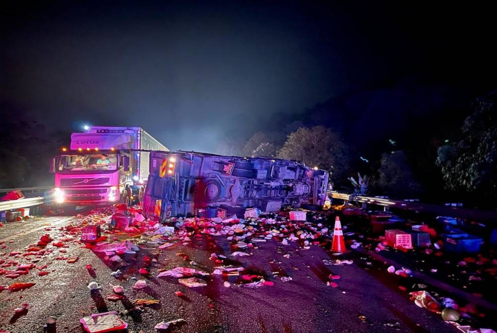 Keadaan lori yang terbalik menghalang laluan kiri lebuh raya dekat Tapah pada pagi Khamis.