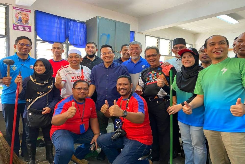 Nik Nazmi (empat dari kiri) bersama sebahagian daripada sukarelawan Program Gerak Kerja Pasca Banjir di SK Bendang Pa' Yong, Tumpat pada Khamis.