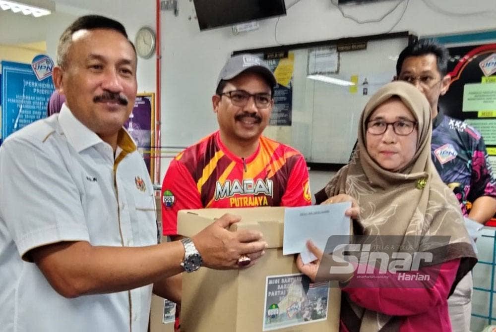 Ruslin menyampaikan sumbangan kepada kakitangan JPN yang terjejas banjir ketika bencana itu dua minggu lalu di Pejabat JPN negeri Kelantan di Pasir Mas pada Jumaat.