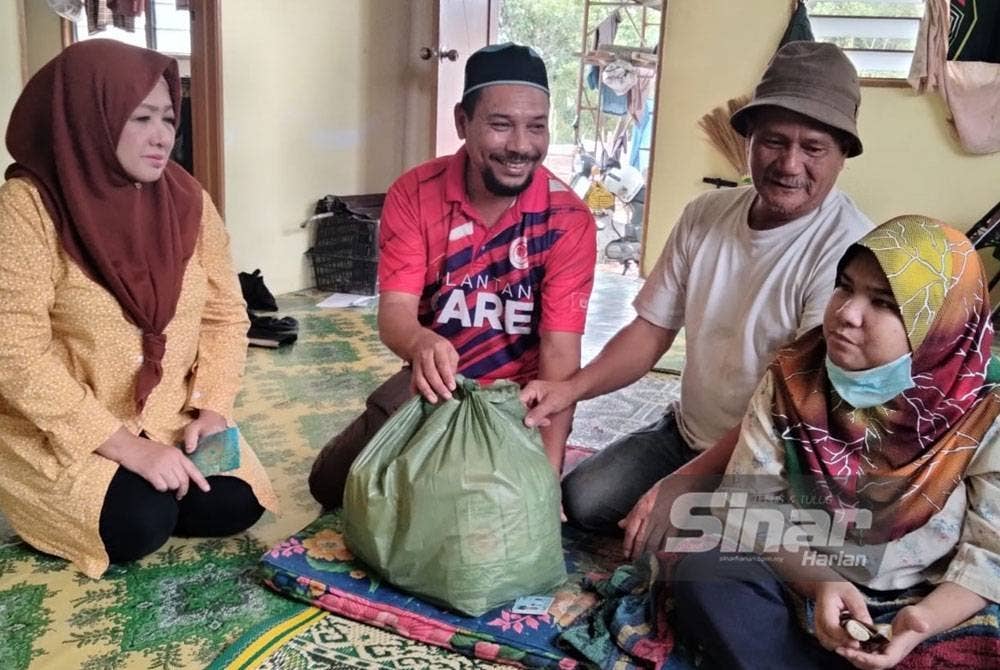 Zulkefli (dua dari kanan) menerima lawatan daripada Che Norhayati dan Ismail di rumahnya di Kampung Gatal.
