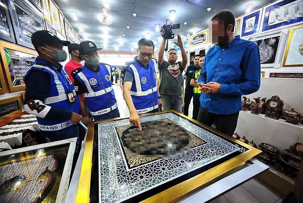 Ahmad Zaki menunjukkan kesilapan pada ayat Kursi yang dijual di salah sbeuah premis yang diperiksa