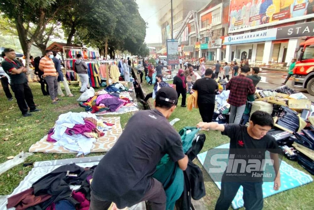 Pekerja Jakel membawa keluar barang barang yang sempat diselamatkan.