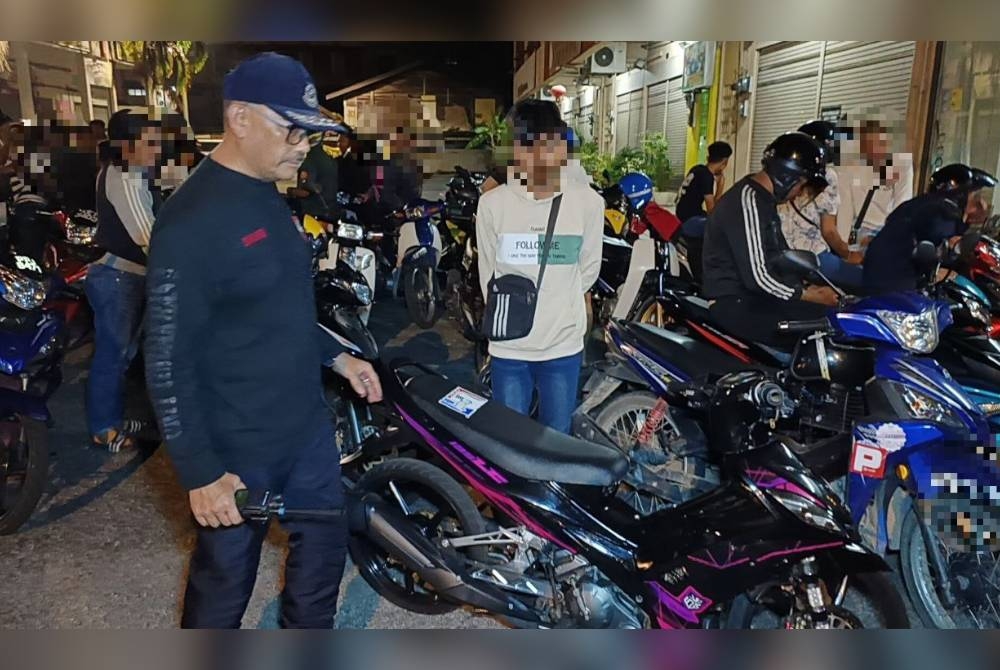 Ahmad Shukri (kiri) turut serta dalam Op Samseng di Jalan Pegawai pada awal pagi Ahad. - Foto Ihsan PDRM