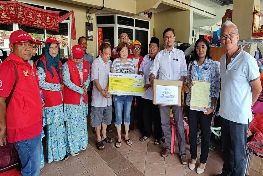 Su Lee (lima dari kiri) menerima sumbangan daripada Perkeso selepas menziarahinya di kediamannya di Taman Mutiara Sabak Bernam di sini pada Rabu.